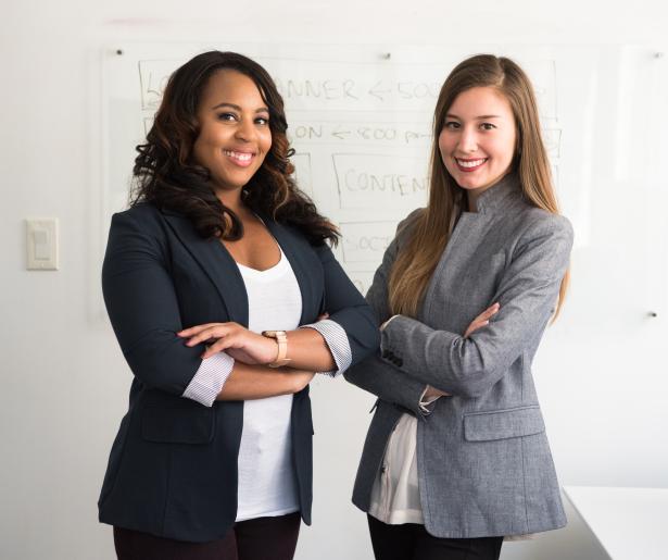 two women standing and smiling